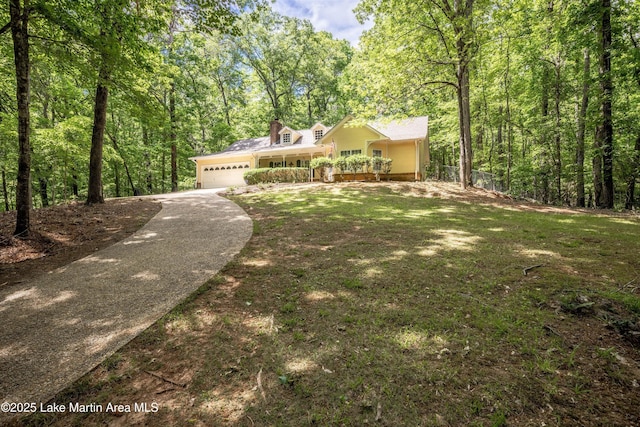 view of front of house featuring a garage, fence, concrete driveway, a porch, and a forest view