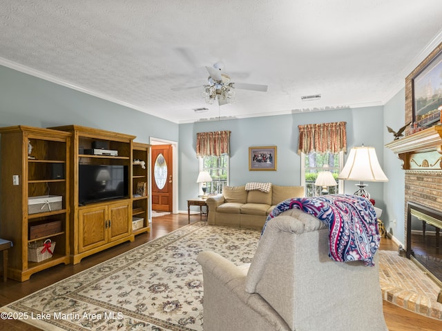 living area featuring a ceiling fan, ornamental molding, and visible vents