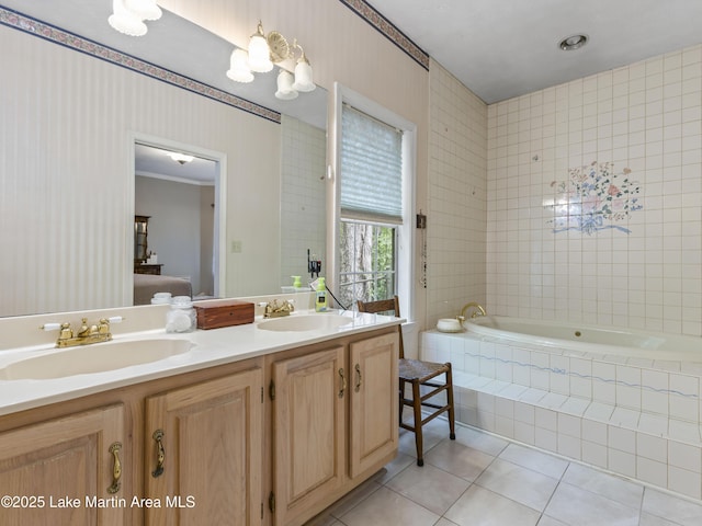 ensuite bathroom featuring a sink, tile patterned flooring, double vanity, and a garden tub