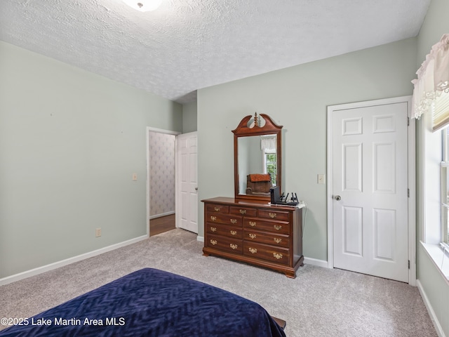 bedroom with baseboards, a textured ceiling, and carpet