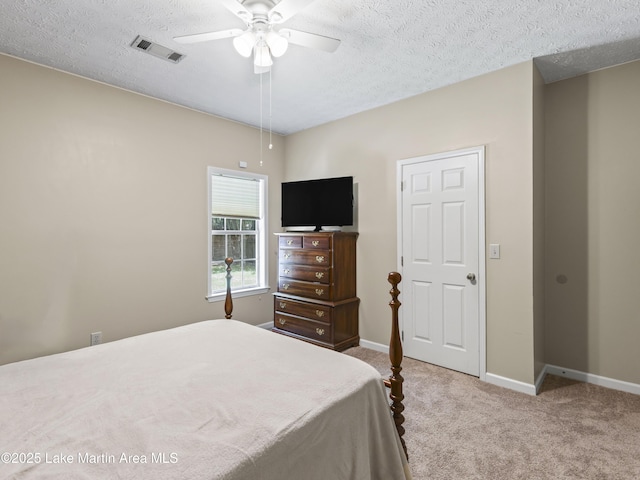 carpeted bedroom featuring a textured ceiling, baseboards, and visible vents