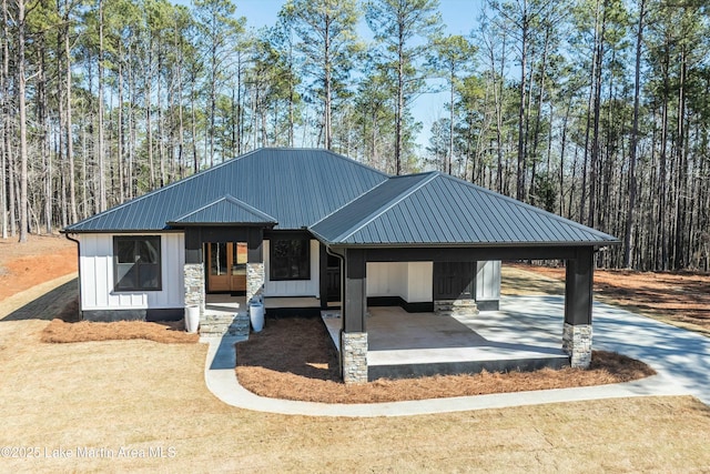 view of front of property with a front yard, stone siding, metal roof, and a gazebo