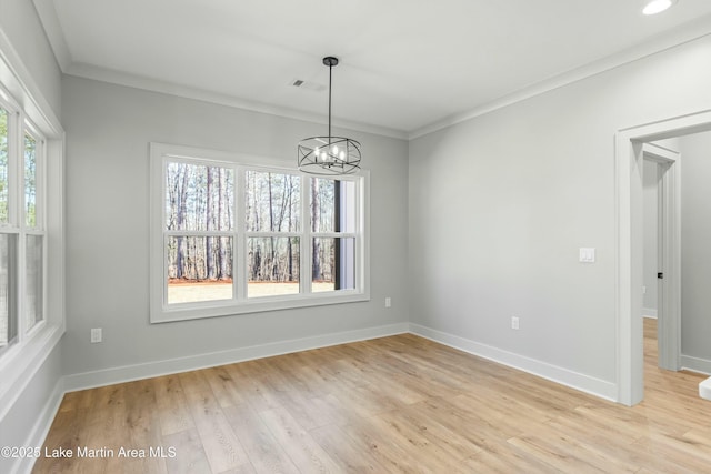 unfurnished dining area featuring a chandelier, visible vents, baseboards, ornamental molding, and light wood-type flooring