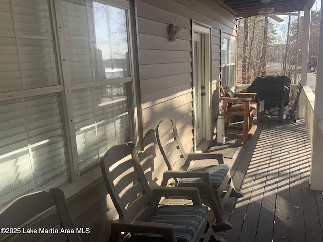 wooden deck with grilling area and ceiling fan