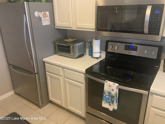 kitchen featuring white cabinetry, appliances with stainless steel finishes, and light tile patterned floors