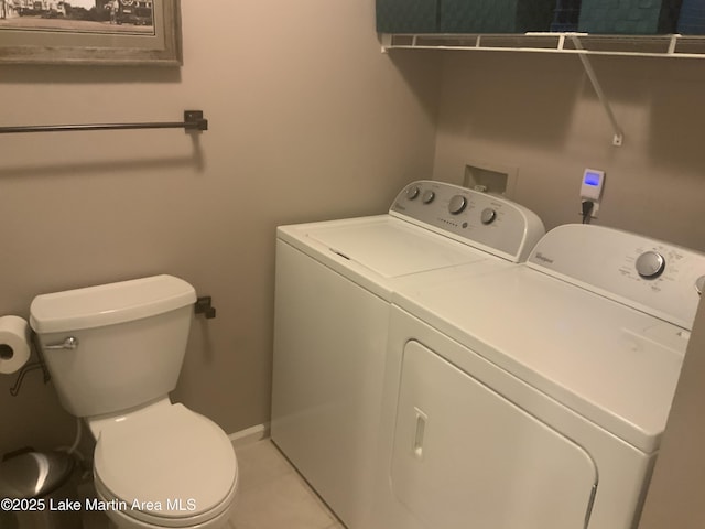 laundry room with independent washer and dryer and light tile patterned floors