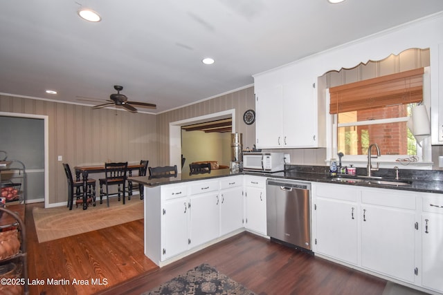 kitchen featuring white microwave, a peninsula, a ceiling fan, dishwasher, and a sink