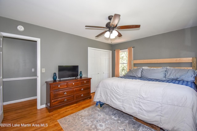 bedroom with a closet, baseboards, ceiling fan, and wood finished floors