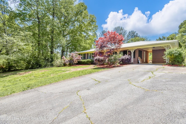 single story home with a carport, driveway, a front yard, and metal roof
