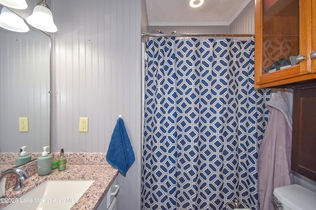 full bathroom with toilet, a tile shower, vanity, and crown molding