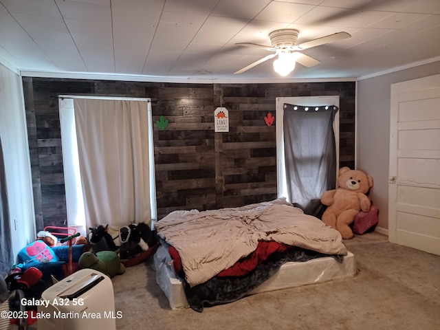 carpeted bedroom with wooden walls and ornamental molding