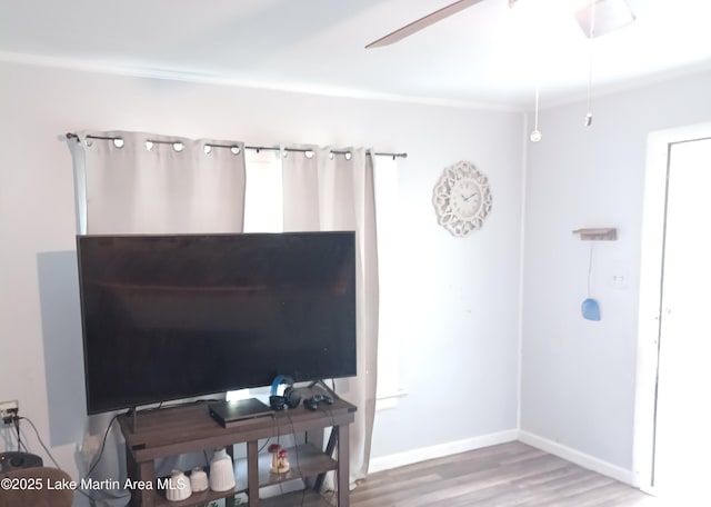 interior space featuring baseboards, wood finished floors, and ceiling fan