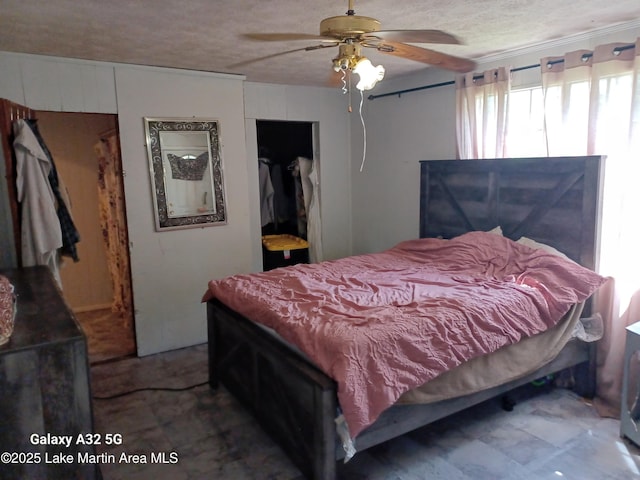 bedroom with a closet, a ceiling fan, and a textured ceiling