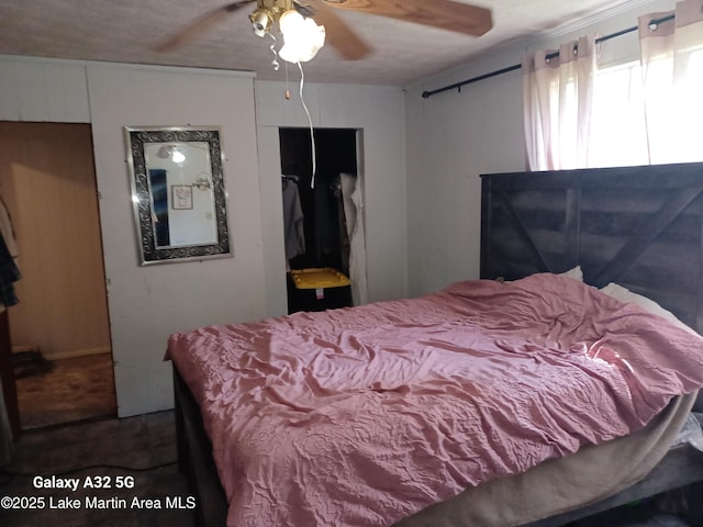 bedroom with a textured ceiling, a ceiling fan, and a closet