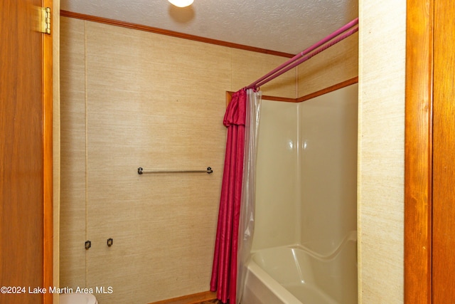 bathroom with shower / bath combination with curtain, crown molding, and a textured ceiling