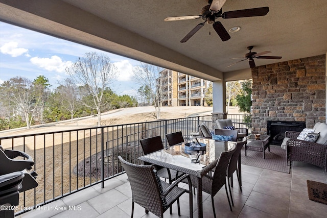 view of patio with an outdoor living space with a fireplace, ceiling fan, and a grill