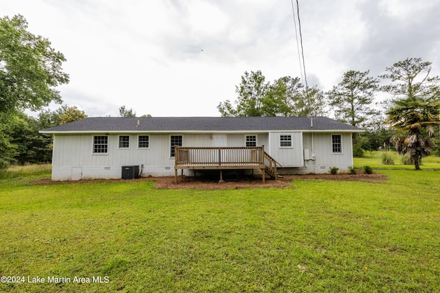 rear view of house with a lawn, a wooden deck, and central AC unit