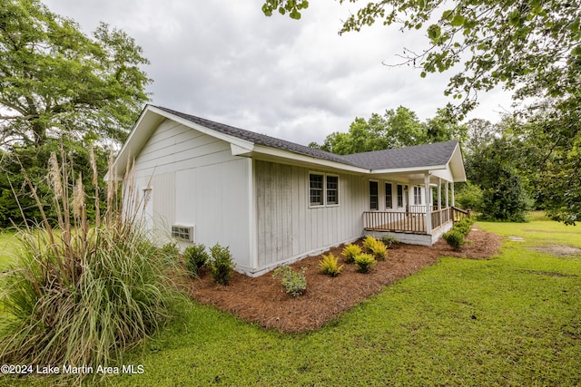 view of side of home with a yard and covered porch