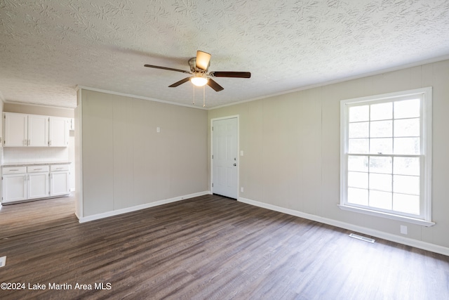 unfurnished room featuring ceiling fan, dark hardwood / wood-style flooring, a textured ceiling, and ornamental molding