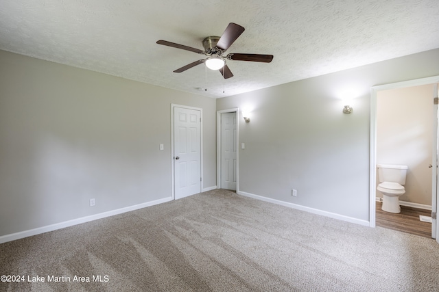 unfurnished bedroom featuring carpet, ceiling fan, a textured ceiling, and ensuite bath