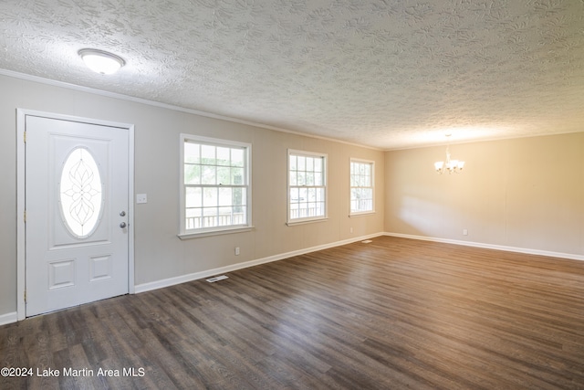 entryway featuring ornamental molding, a textured ceiling, an inviting chandelier, and dark wood-type flooring