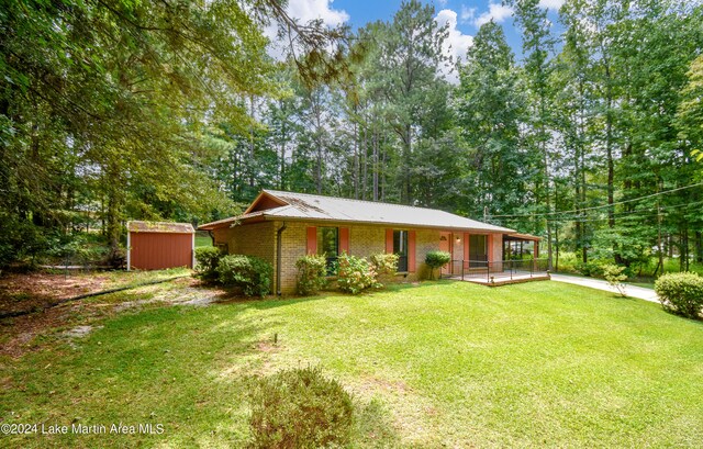 ranch-style home with a front yard and a shed