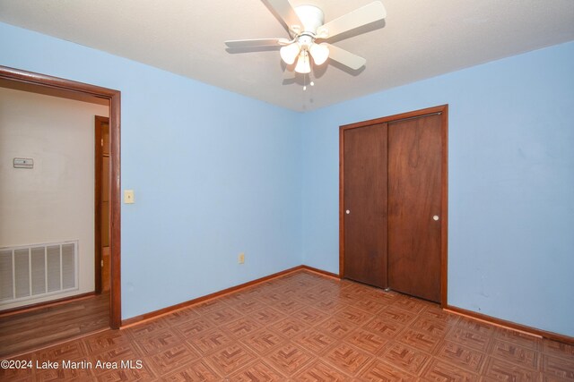 unfurnished bedroom with ceiling fan and a closet