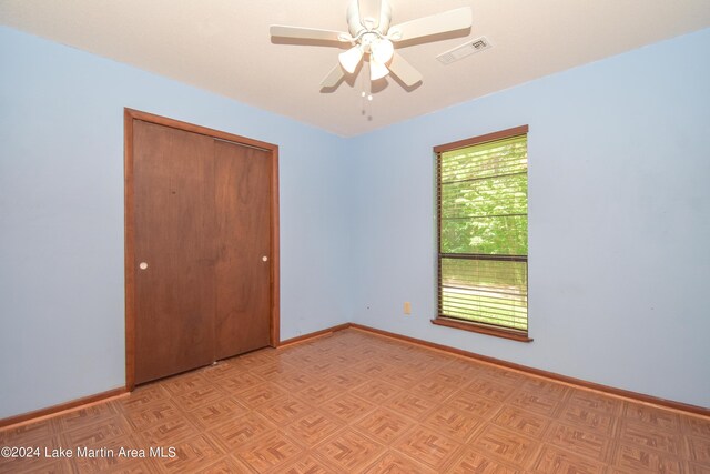 unfurnished bedroom with ceiling fan and a closet