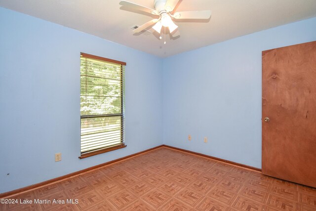 unfurnished room featuring ceiling fan and light parquet floors