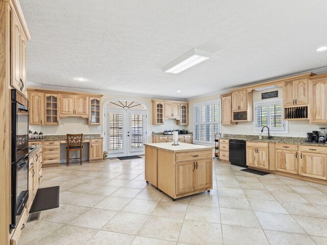 kitchen with black appliances, a kitchen island, crown molding, and sink