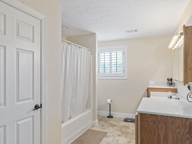 bathroom featuring shower / bath combo with shower curtain, vanity, and a textured ceiling