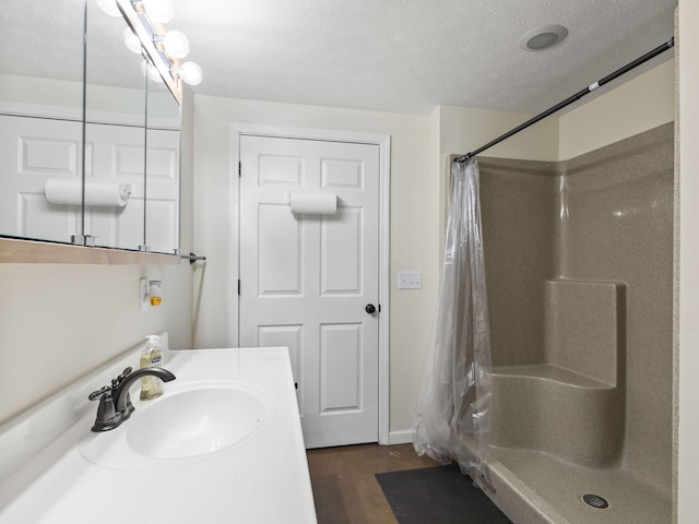 bathroom featuring hardwood / wood-style floors, vanity, a textured ceiling, and a shower with shower curtain