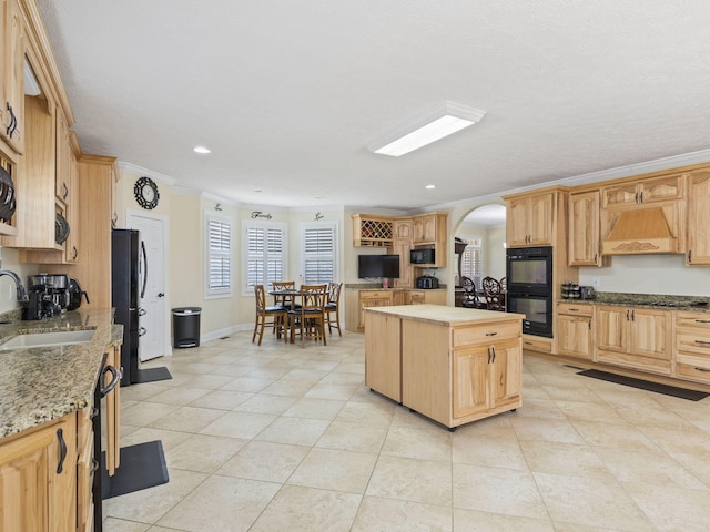 kitchen with sink, premium range hood, a kitchen island, black appliances, and ornamental molding