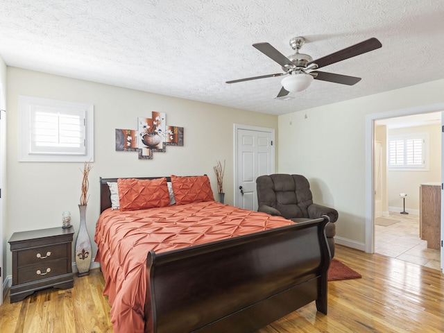 bedroom featuring a textured ceiling, light hardwood / wood-style floors, and ceiling fan