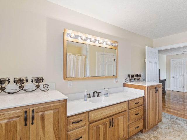 bathroom with vanity, wood-type flooring, and a textured ceiling