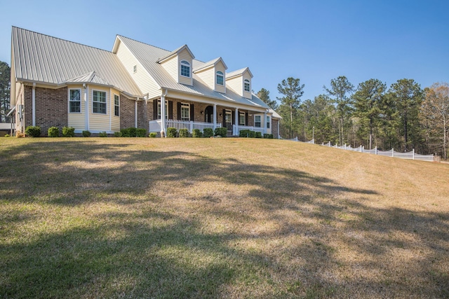 new england style home featuring a front yard and covered porch