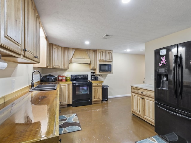 kitchen with light brown cabinetry, premium range hood, a textured ceiling, sink, and black appliances