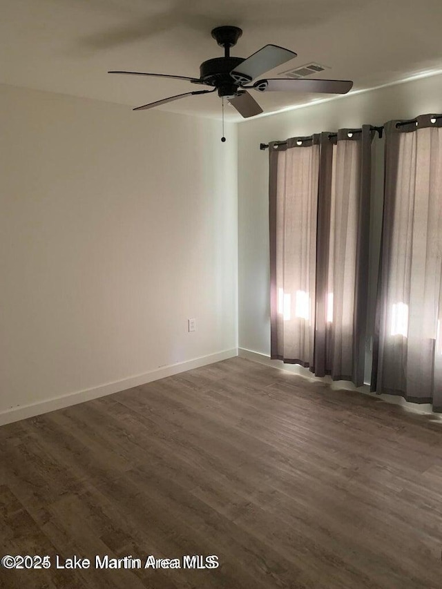 empty room with ceiling fan and dark hardwood / wood-style floors