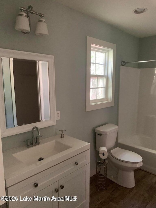 full bathroom with vanity, toilet, shower / bathtub combination, and hardwood / wood-style floors