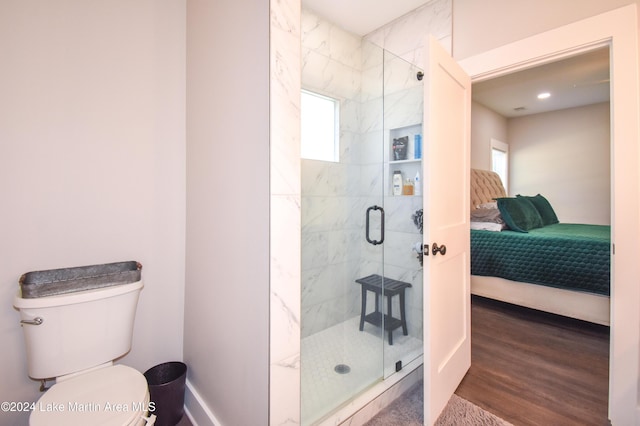 bathroom featuring hardwood / wood-style floors, an enclosed shower, and toilet