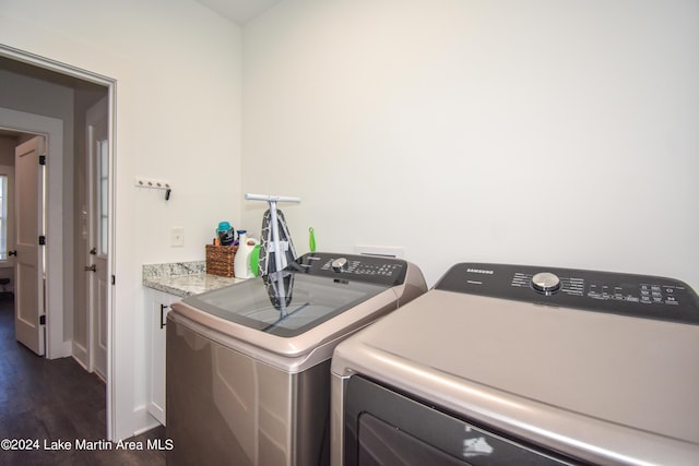 laundry room featuring cabinets, separate washer and dryer, and dark hardwood / wood-style floors