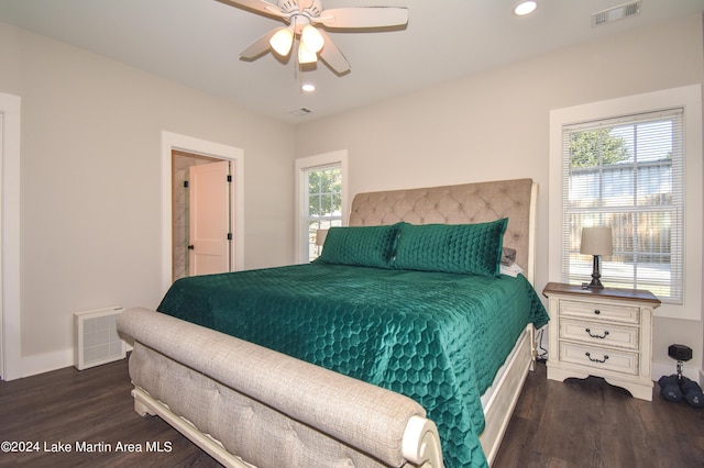 bedroom featuring ceiling fan, dark wood-type flooring, and multiple windows