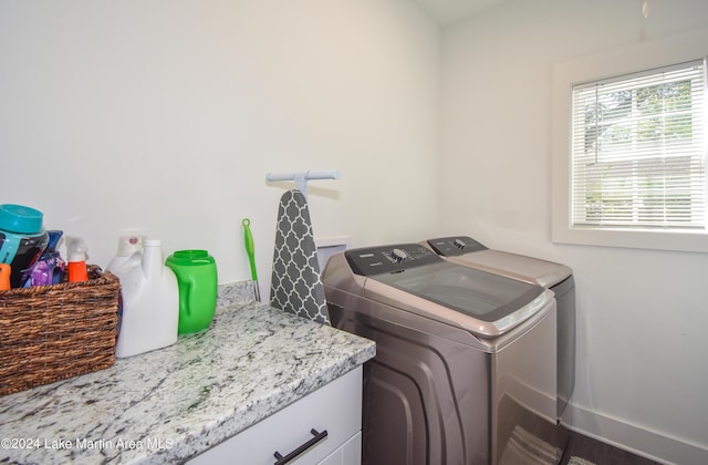 laundry room featuring washing machine and clothes dryer and cabinets