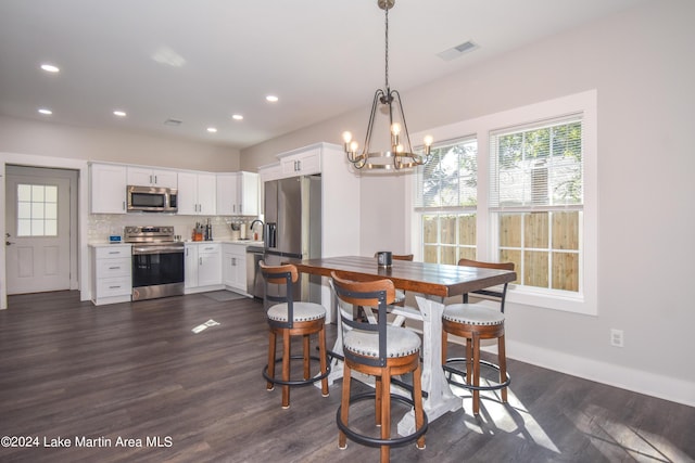 dining room featuring dark hardwood / wood-style floors, a notable chandelier, and sink