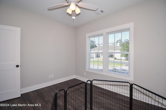 unfurnished bedroom featuring ceiling fan and dark hardwood / wood-style flooring