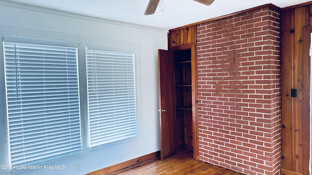 interior space with ceiling fan, wooden walls, and hardwood / wood-style flooring