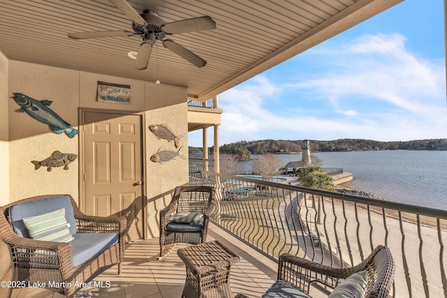 balcony with a water view and ceiling fan
