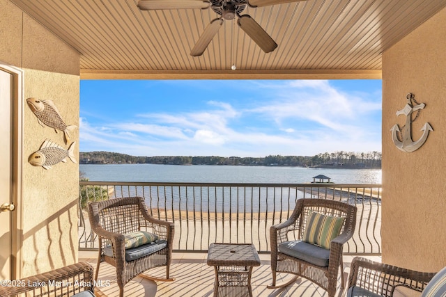 balcony with a sunroom, a water view, and a ceiling fan
