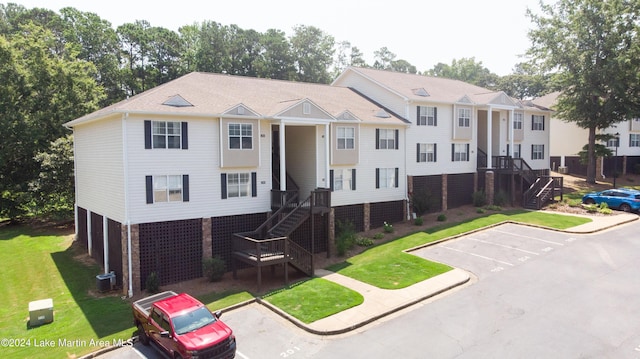 view of front of home with cooling unit and a front lawn