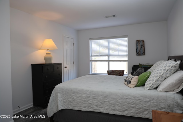 bedroom with dark hardwood / wood-style flooring